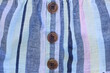 © butus - texture of three brown plastic buttons on colored striped fabric clothes
