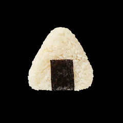 A close-up view of a triangular rice ball wrapped in seaweed against a dark background, showcasing traditional Japanese cuisine