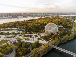 Wall Mural - Aerial view of Montreal Biosphere in autumn sunset time. St. Lawrence River, Jacques Cartier Bridge in the background. Jean-Drapeau Park, Saint Helen's Island, Montreal, Quebec, Canada.