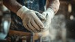 © inthasone - Close-up of a worker male hands with work gloves on, clapping to remove sawdust while working in the workshop at home.