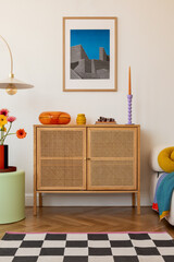 Fresh blooms in bright orange and yellow sit atop a wooden sideboard, framed by geometric decor and a retro glass dish, creating a cheerful modern space. Mock up.