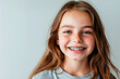 © Katie R - smiling girl with braces on plain light background