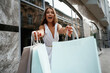 © standret - Extremely happy with new stuff. Stylish woman is with shopping bag outdoors near the building