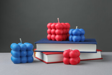 Wall Mural - Beautiful bubble candles and books on grey table