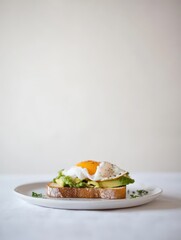 Wall Mural - A plate of avocado toast topped with a poached egg and garnished with herbs.