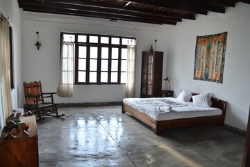 Leinwandbilder - The bedroom is a modern luxury summer holiday or vacation wooden beach house with a white bed and a beautiful sunny exterior view through the door and the window.