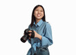 © Prostock-studio - Happy Japanese Photographer Lady Posing Holding Photo Camera Over White Studio Background. Professional Creative Photography Career And Education Concept. Isolated