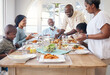 © Flashizzle/peopleimages.com - Chicken, help and food with black family in home for Thanksgiving celebration, festive holiday and brunch. Support, love and party with people and lunch for nutrition, grateful and tradition event