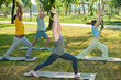 © pressmaster - Side view of blond mature woman in activewear stretching legs and raising arms over her head while showing exercise to elderly people