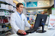 © StarDweller/peopleimages.com - Store, pharmacist and man on computer for healthcare, service or check medicine inventory. Pharmacy, desktop and medical professional in drugstore for stock, sales or online email at checkout counter