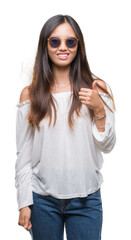 Young asian woman wearing sunglasses over isolated background doing happy thumbs up gesture with hand. Approving expression looking at the camera with showing success.