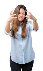 Wall Mural - Young beautiful brunette business woman over isolated background Shouting frustrated with rage, hands trying to strangle, yelling mad