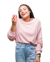 Young african american girl eating cupcake over isolated background with a happy face standing and smiling with a confident smile showing teeth