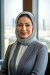 © AI_images_for_people - A middle-aged Arabian businesswoman, with a confident and friendly smile, poses in a well-appointed office. Her attire is professional, and the office features elegant furnishings and a view of the