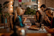 © Marko Geber - Diverse students eating pizza while studying together at home