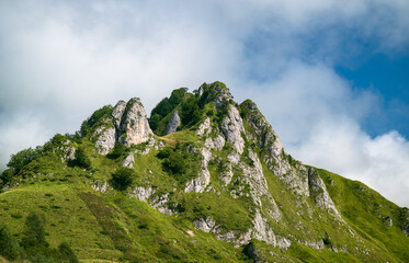 Mountain landscape with green grass and blue sky with clouds in summer