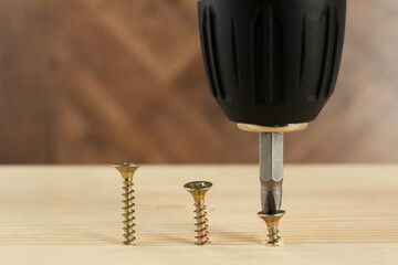 Wall Mural - Screwing screw into wooden plank, closeup view