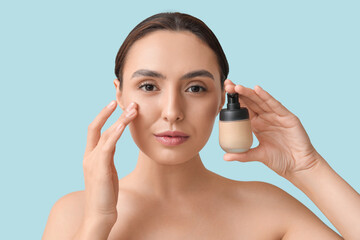 Poster - Young woman with makeup foundation on blue background, closeup