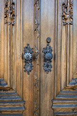 Wall Mural - Vintage decorative forged iron or brass round door locks on a hardwood door. Exterior view, close up shot, shallow depth of field, no people