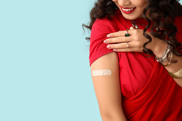 beautiful indian woman in sari with applied medical patch on blue background