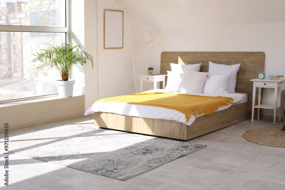 Comfortable bed, plaid and bedside table in stylish bedroom