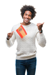 Wall Mural - Afro american man flag of Spain over isolated background pointing and showing with thumb up to the side with happy face smiling