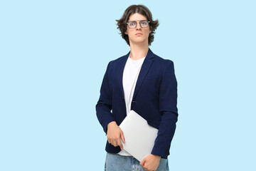 Male programmer in eyeglasses with laptop on blue background