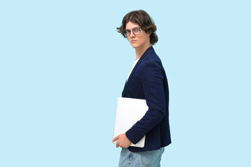 Male programmer in eyeglasses with laptop on blue background