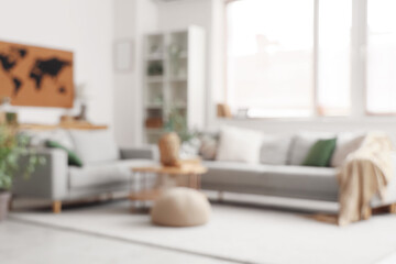 Poster - Blurred view of living room with comfortable sofas, shelving unit and world map on white wall