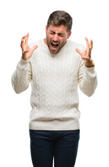 Young handsome man wearing winter sweater over isolated background celebrating mad and crazy for success with arms raised and closed eyes screaming excited. Winner concept