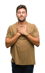 Wall Mural - Young handsome man over isolated background smiling with hands on chest with closed eyes and grateful gesture on face. Health concept.