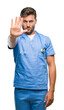 © Krakenimages.com - Young handsome doctor surgeon man over isolated background doing stop sing with palm of the hand. Warning expression with negative and serious gesture on the face.
