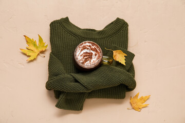 Wall Mural - Autumn composition with cup of cocoa, sweater and autumn leaves on beige background