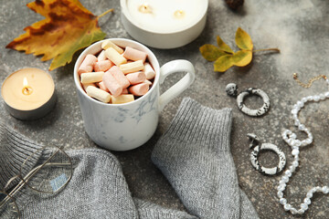 Poster - Autumn composition with cup of cocoa with marshmallow, sweater and accessories on grey grunge background, closeup