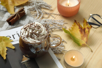 Poster - Autumn composition with cup of cocoa, magazine and burning candles on wooden background, closeup