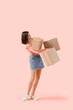 © Pixel-Shot - Beautiful young shocked woman dropping parcels on pink background