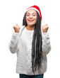© Krakenimages.com - Young braided hair african american girl wearing christmas hat over isolated background celebrating surprised and amazed for success with arms raised and open eyes. Winner concept.