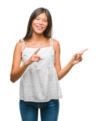 Wall Mural - Young asian woman over isolated background smiling and looking at the camera pointing with two hands and fingers to the side.