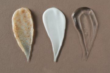 Wall Mural - smears of different cosmetic products on grey background, flat lay
