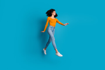 Canvas Print - Full length photo of lovely young lady running jump dressed stylish yellow garment isolated on blue color background