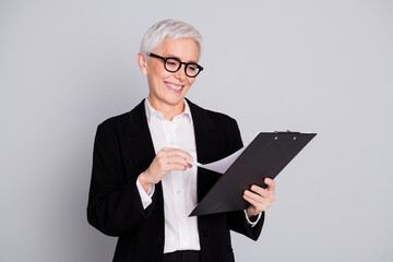 Poster - Photo portrait of attractive mature woman professional ceo read check documents dressed formalwear specs isolated on gray color background