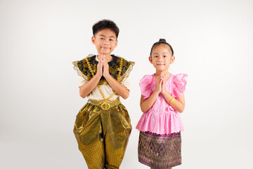 Portrait Thailand kid boy and girl smiling traditional Thai dress costume posing to pay respect in studio isolated white background, Happy primary and kindergarten children sawasdee symbol or welcome