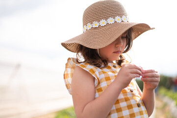 A young girl wearing a yellow and white checkered dress