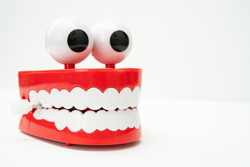 Tooth funny toy denture red color jaw and eye on white background with copy space.