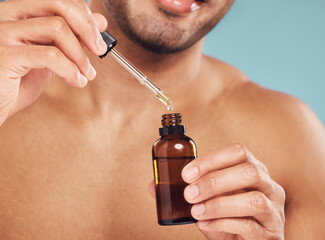 Poster - Skincare, hands and man with serum in bottle, facial treatment product and skin glow on blue background. Cosmetics, retinol liquid and male person with oil, pipette or collagen solution in studio