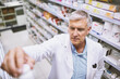 © JordaanExams/peopleimages.com - Reading, product and mature man in pharmacy, antibiotics and inventory for medicine, store and expiry date of pills. Healthcare, wellness and pharmacist with container, serious and info with label