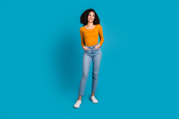 Canvas Print - Full length photo of lovely young lady hands pockets look empty space dressed stylish yellow garment isolated on blue color background