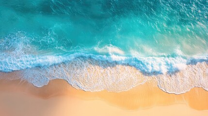 Aerial image of a brilliant blue sea on a clear, sunny day, featuring splashing waves and a sandy coastline