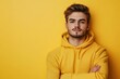 © MUdaylah - Portrait of handsome young man in yellow hoodie on color background with generative ai