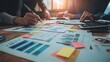 © BrilliantPixels - Close-up of Hand Holding Pen Over Business Charts and Sticky Notes, Teamwork, Collaboration, Analysis, Data, Meeting, Strategy